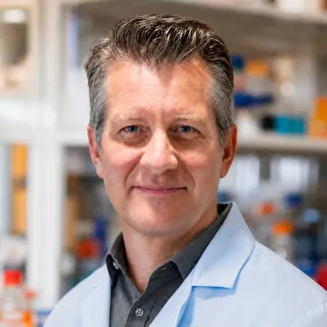 Bill Hitchcock in a lab coat, standing in a laboratory