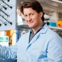 Bill Hitchcock in a lab coat, standing in a laboratory